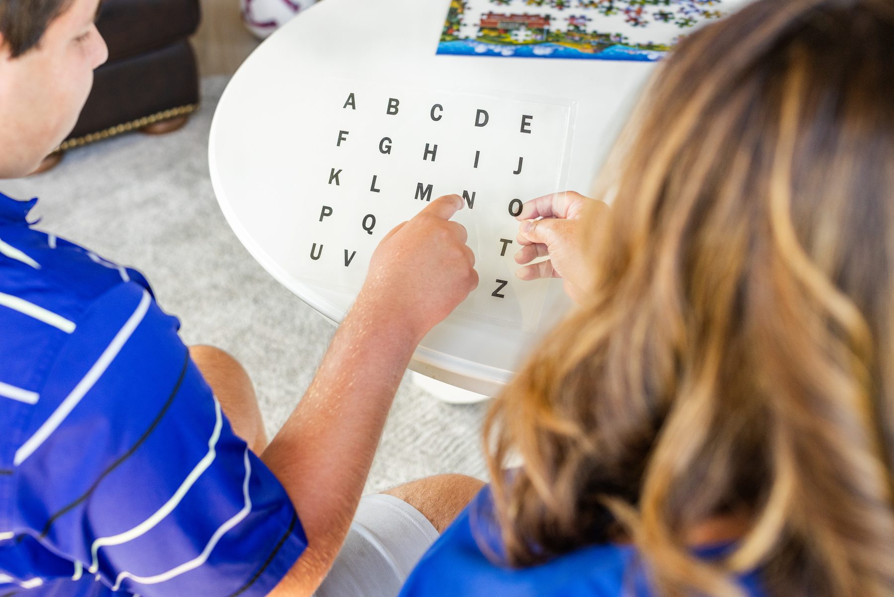 Hands at a letter board during a spelling session